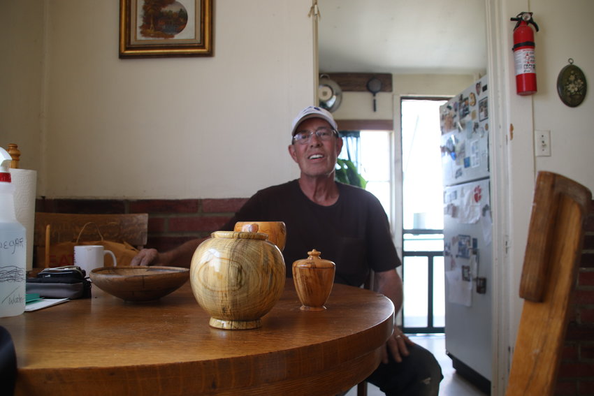 Robert Nesladek with three vases he created out of the leftover wood from a wildfire.